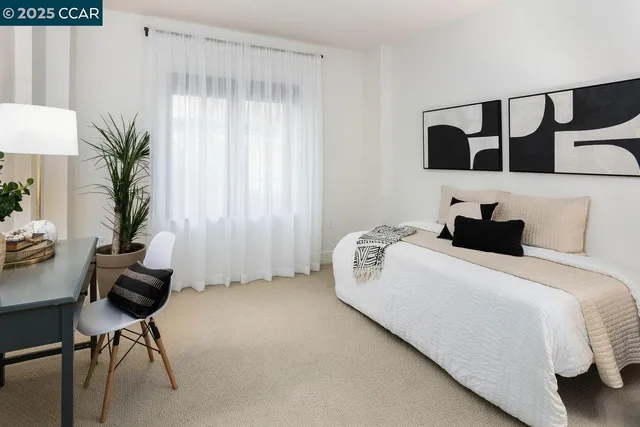 a bedroom with a bed and a potted plant on the dresser