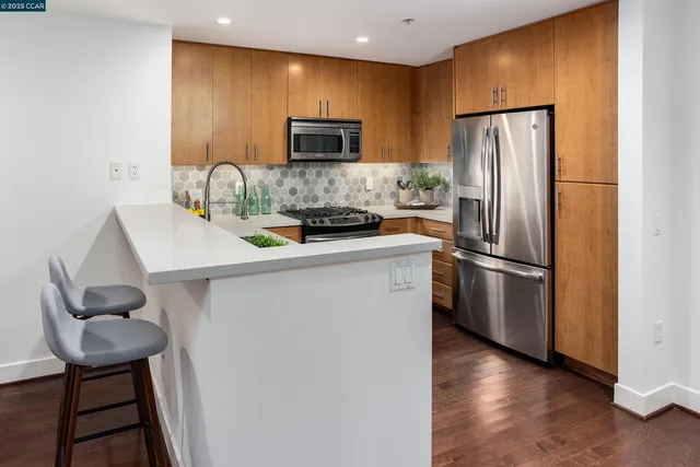 a kitchen with a refrigerator a microwave a sink and cabinets