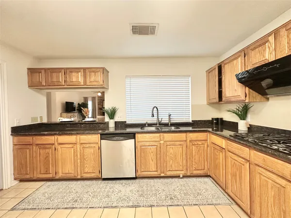 a kitchen with stainless steel appliances granite countertop a sink stove and cabinets