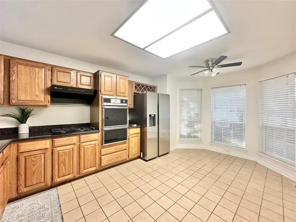 a kitchen with stainless steel appliances granite countertop a refrigerator and a sink