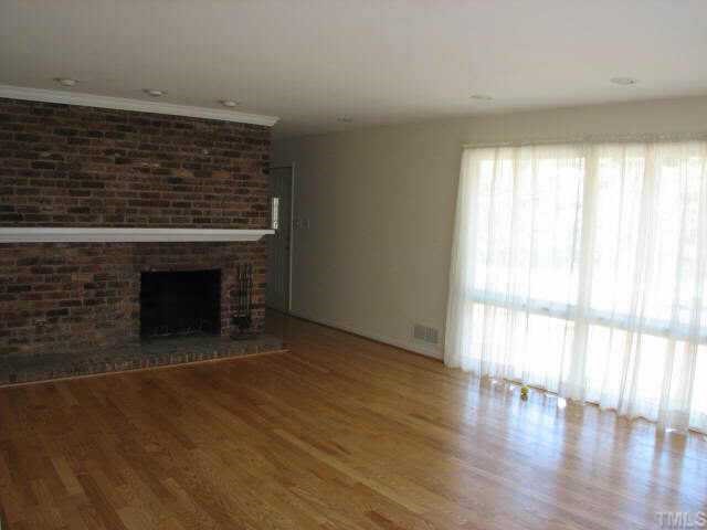 810 Faircloth Street Raleigh, NC 27607 - Photo 2 of 10 a view of empty room with wooden floor and fireplace
