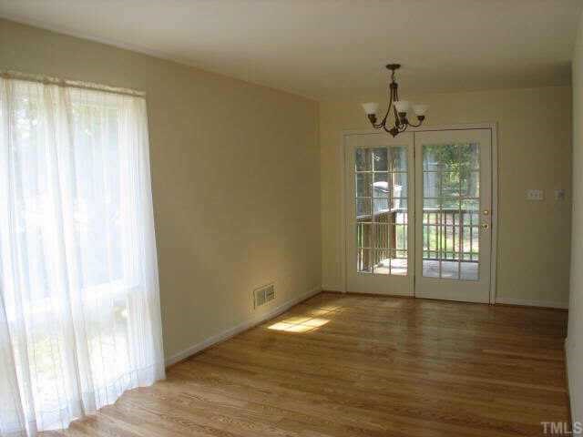 810 Faircloth Street Raleigh, NC 27607 - Photo 4 of 10 a view of an empty room with wooden floor and a window