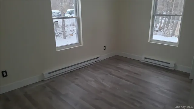 a view of room with window and wooden floor