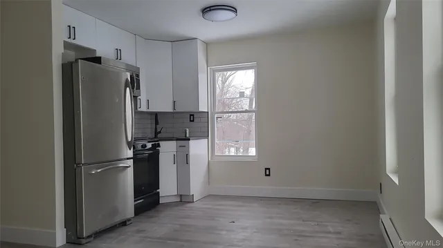 a metallic refrigerator freezer sitting in a kitchen