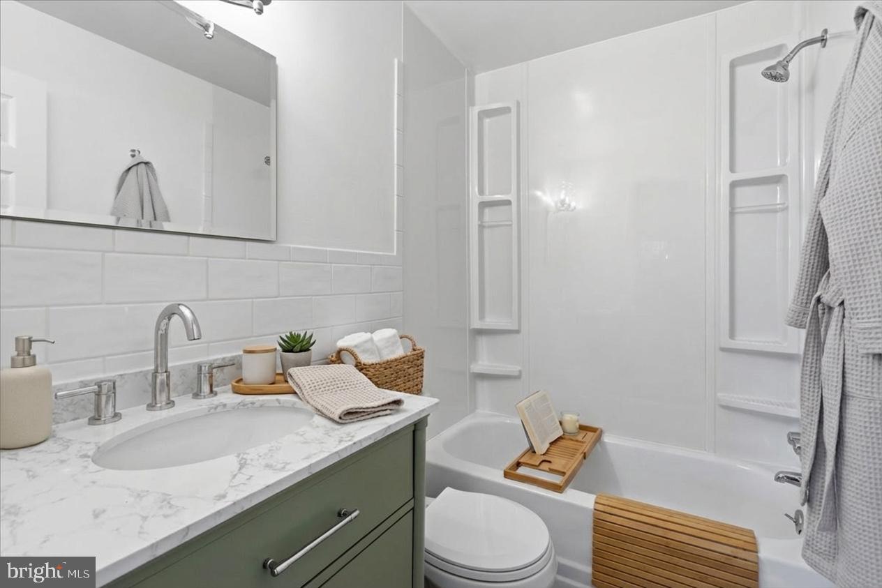 4705 Eads Street Northeast Washington, DC 20019 - Photo 5 of 16 a bathroom with a granite countertop sink toilet and shower