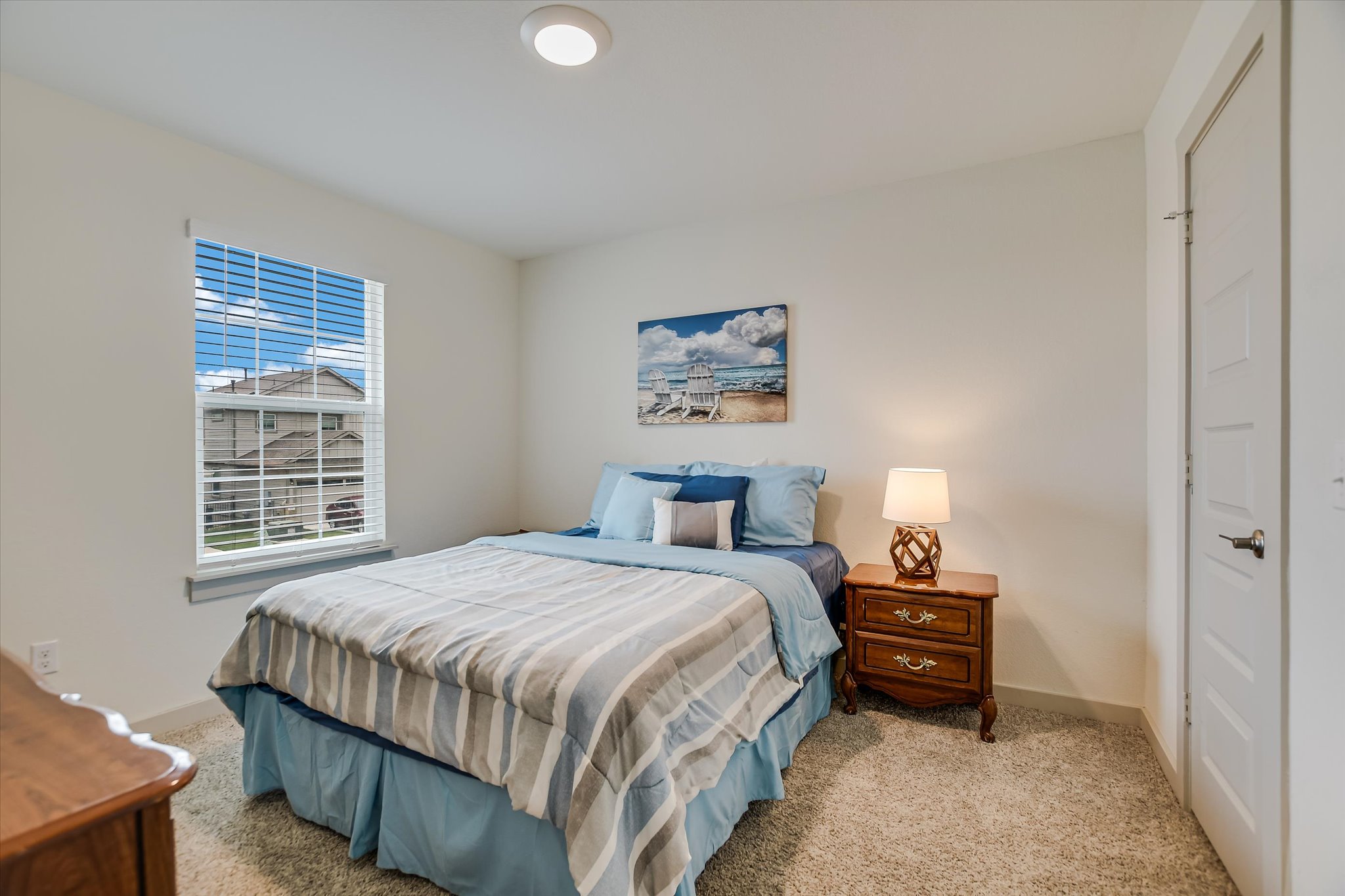 105 Merrick Road Georgetown, TX 78628 - Photo 16 of 23 A well-lit bedroom provides a serene retreat with soft carpeting and a window offering a glimpse of the neighborhood.