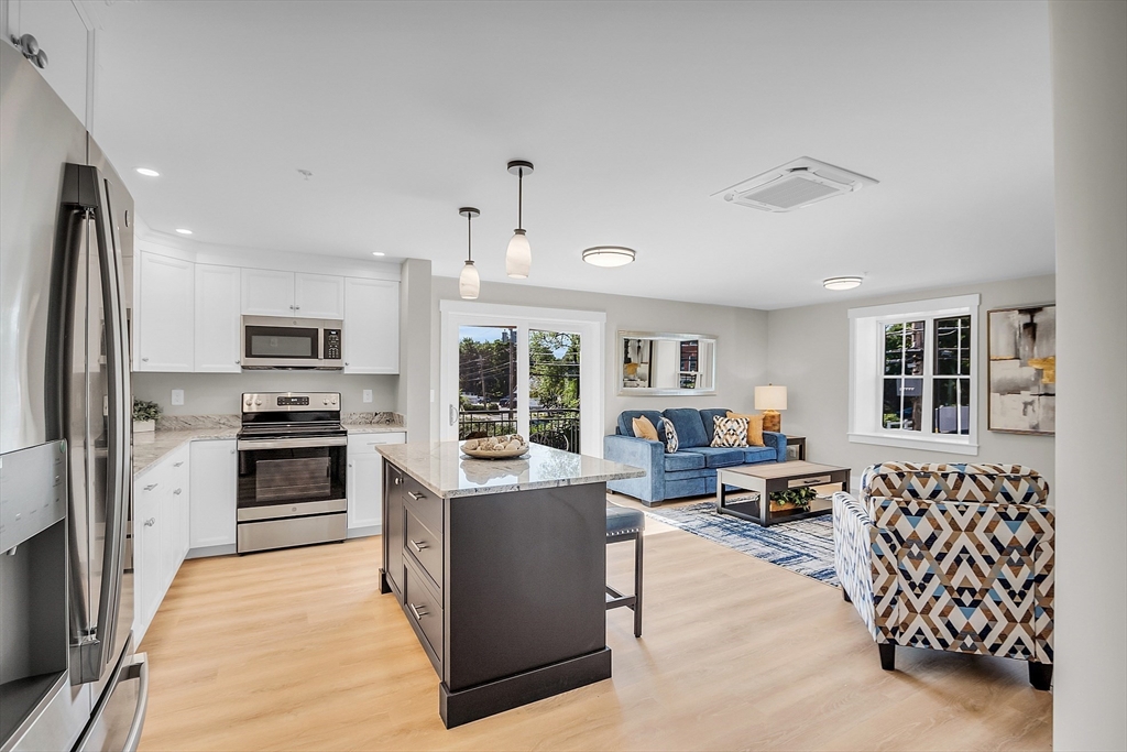 50 Main Street, Unit 101 Pepperell, MA 01463 - Photo 6 of 20 a large kitchen with stainless steel appliances granite countertop a stove and a refrigerator