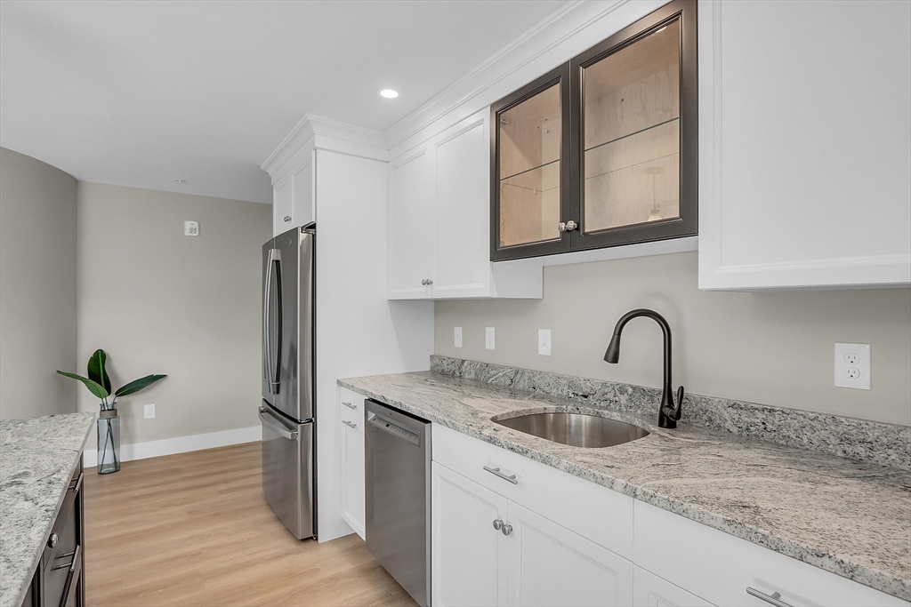 50 Main Street, Unit 101 Pepperell, MA 01463 - Photo 7 of 20 a kitchen with stainless steel appliances granite countertop a sink a refrigerator and a granite counter tops