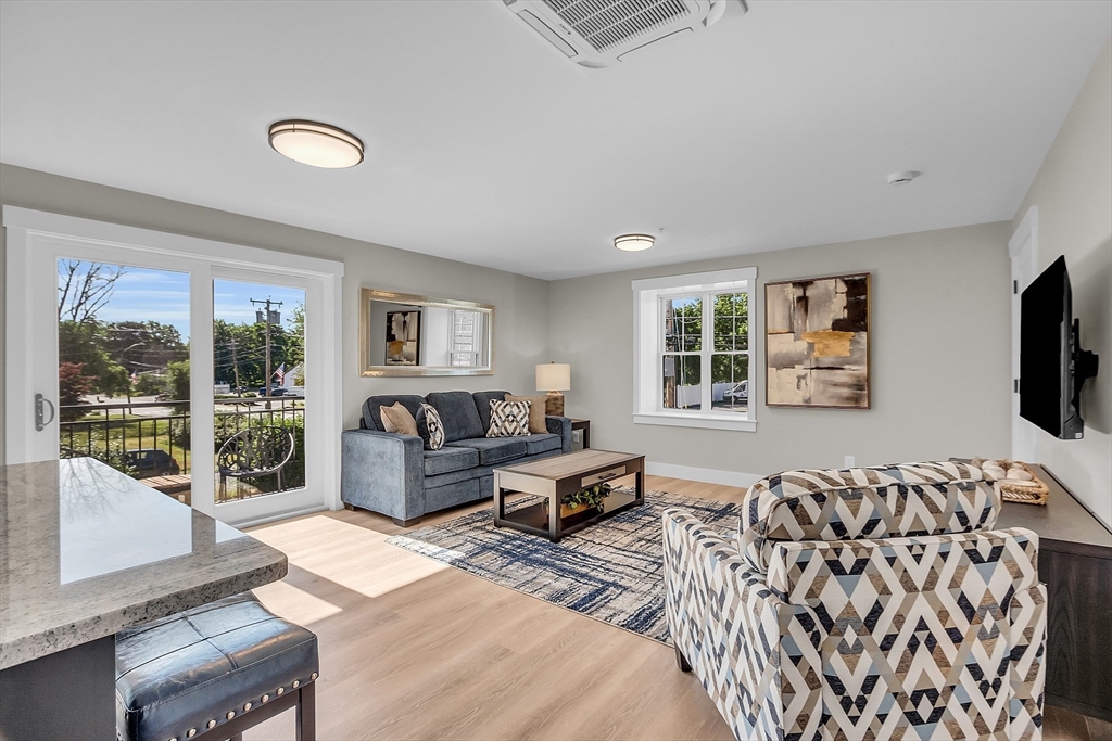 50 Main Street, Unit 101 Pepperell, MA 01463 - Photo 9 of 20 a living room with furniture large window and flat screen tv