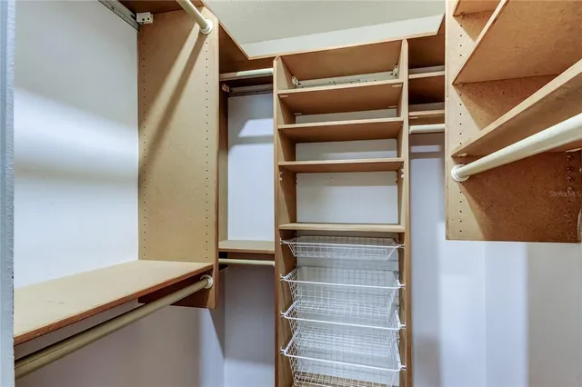 a view of walk in closet with empty racks