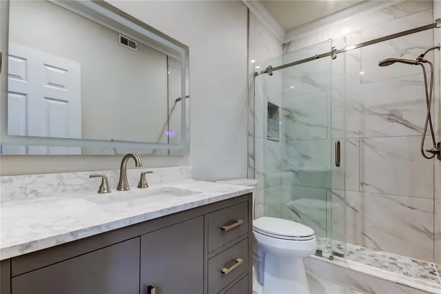 a bathroom with a sink a toilet and shower