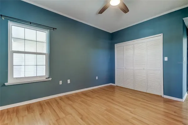 an empty room with ceiling fan and window
