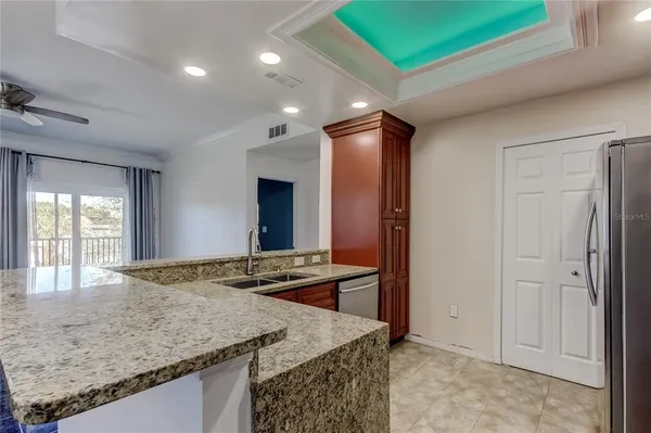 a kitchen with stainless steel appliances granite countertop a sink and a refrigerator