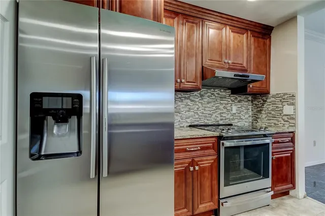 a kitchen with a refrigerator and a stove