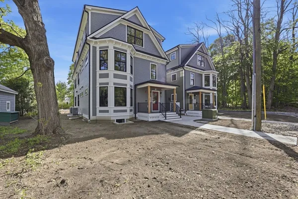 a front view of a house with a yard and trees