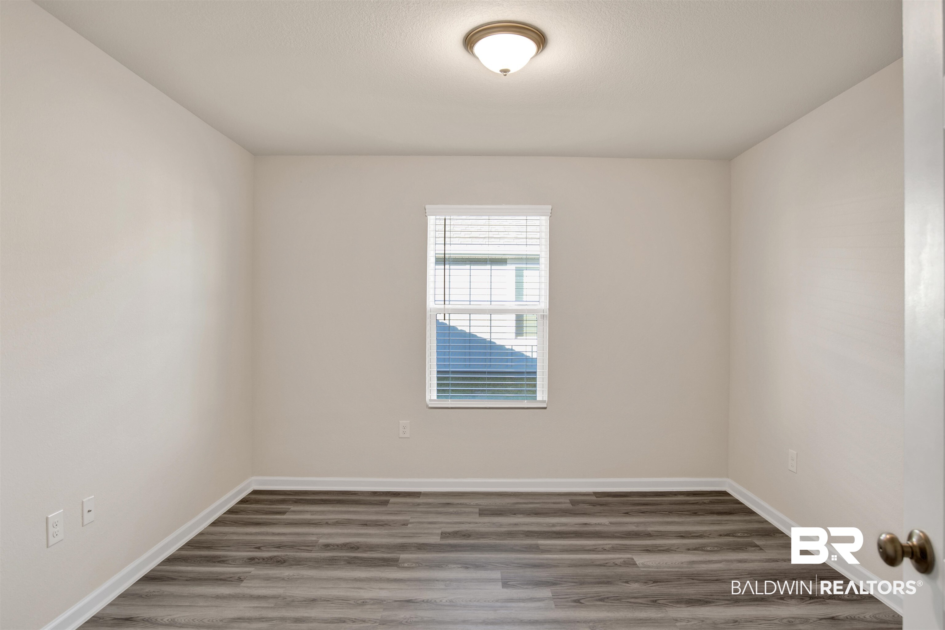 32038 Lyon Road Daphne, AL 36527 - Photo 12 of 30 Empty room featuring wood finished floors and baseboards