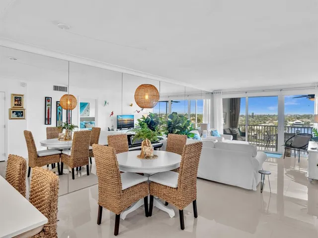 a view of a dining room and livingroom with furniture wooden floor and a rug