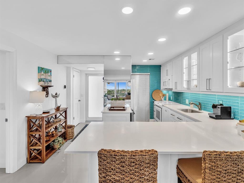 3100 South Ocean Boulevard, Unit 712 Highland Beach, FL 33487 - Photo 15 of 50 a kitchen with stainless steel appliances kitchen island granite countertop a refrigerator and a sink