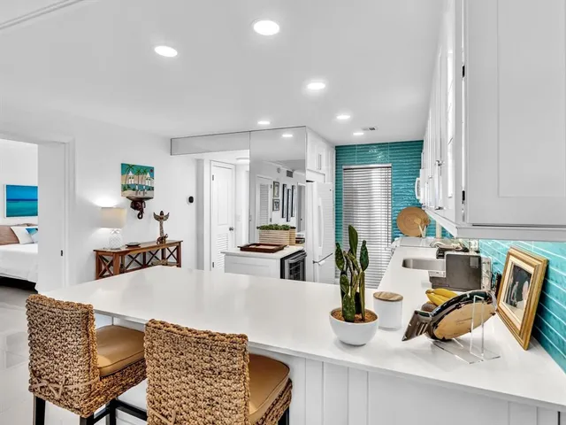 a kitchen with a table chairs and a living room