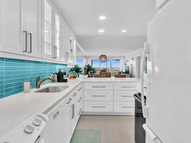 a kitchen with granite countertop white cabinets and white appliances
