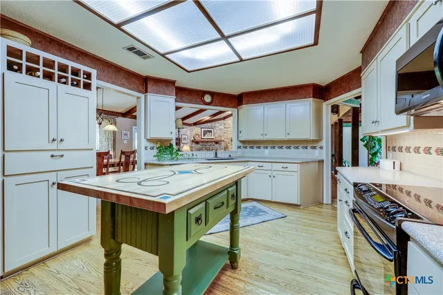 a kitchen with a stove a sink dishwasher and a refrigerator with wooden floor