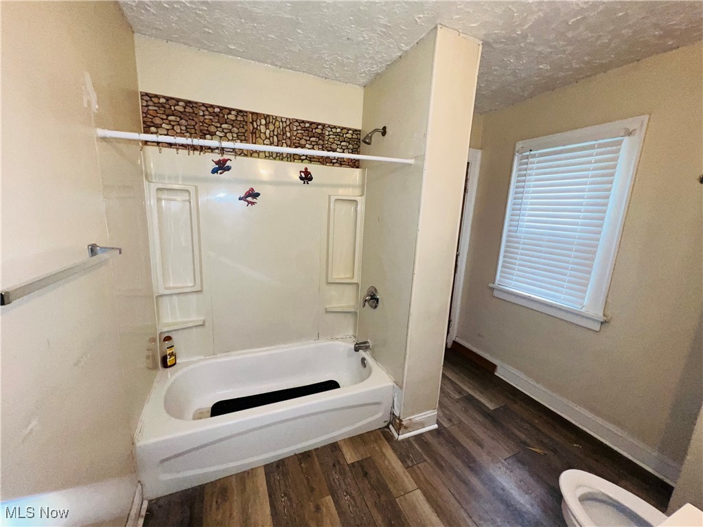 968 Whitby Road Cleveland Heights, OH 44112 - Photo 6 of 19 Bathroom featuring shower / tub combination, dark wood-type flooring, and a textured ceiling