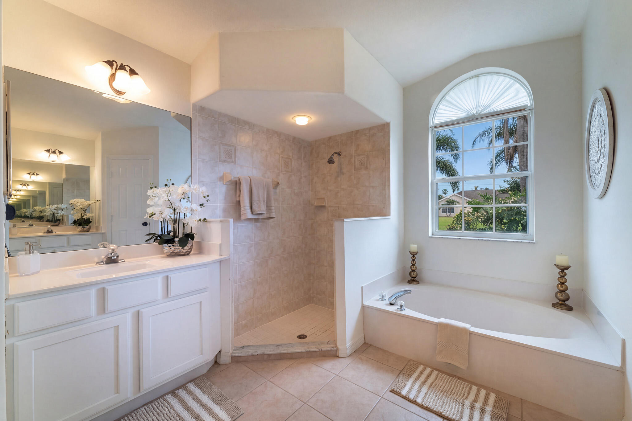 513 Southeast Cliff Road Port St. Lucie, FL 34984 - Photo 21 of 31 a bathroom with a bathtub a sink and a large mirror