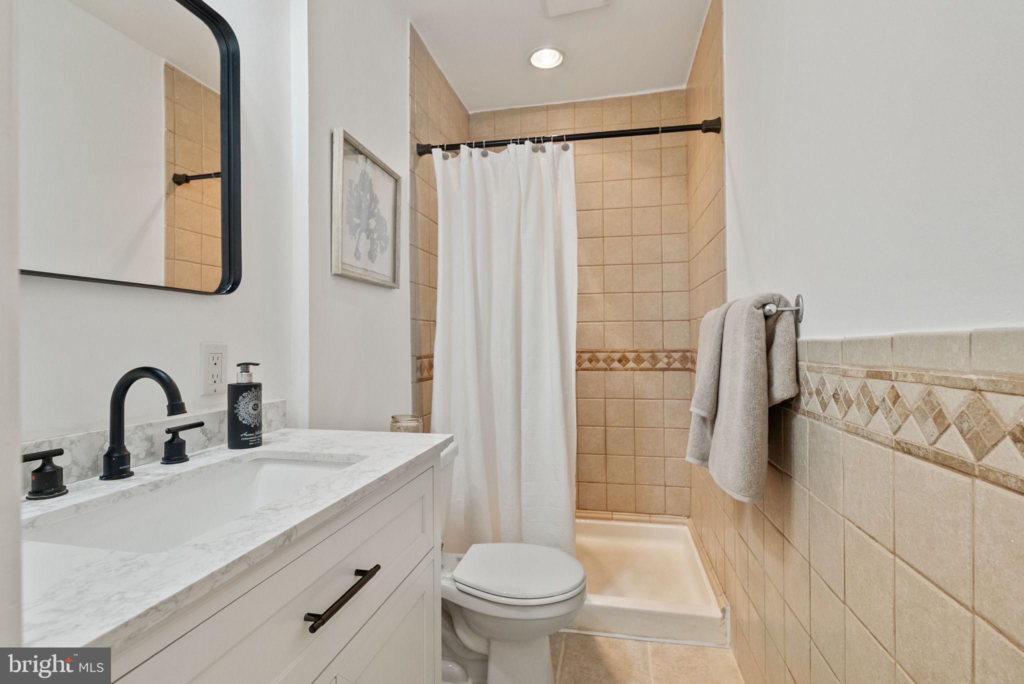 11026 Saffold Way Reston, VA 20190 - Photo 13 of 30 a bathroom with a sink toilet and shower