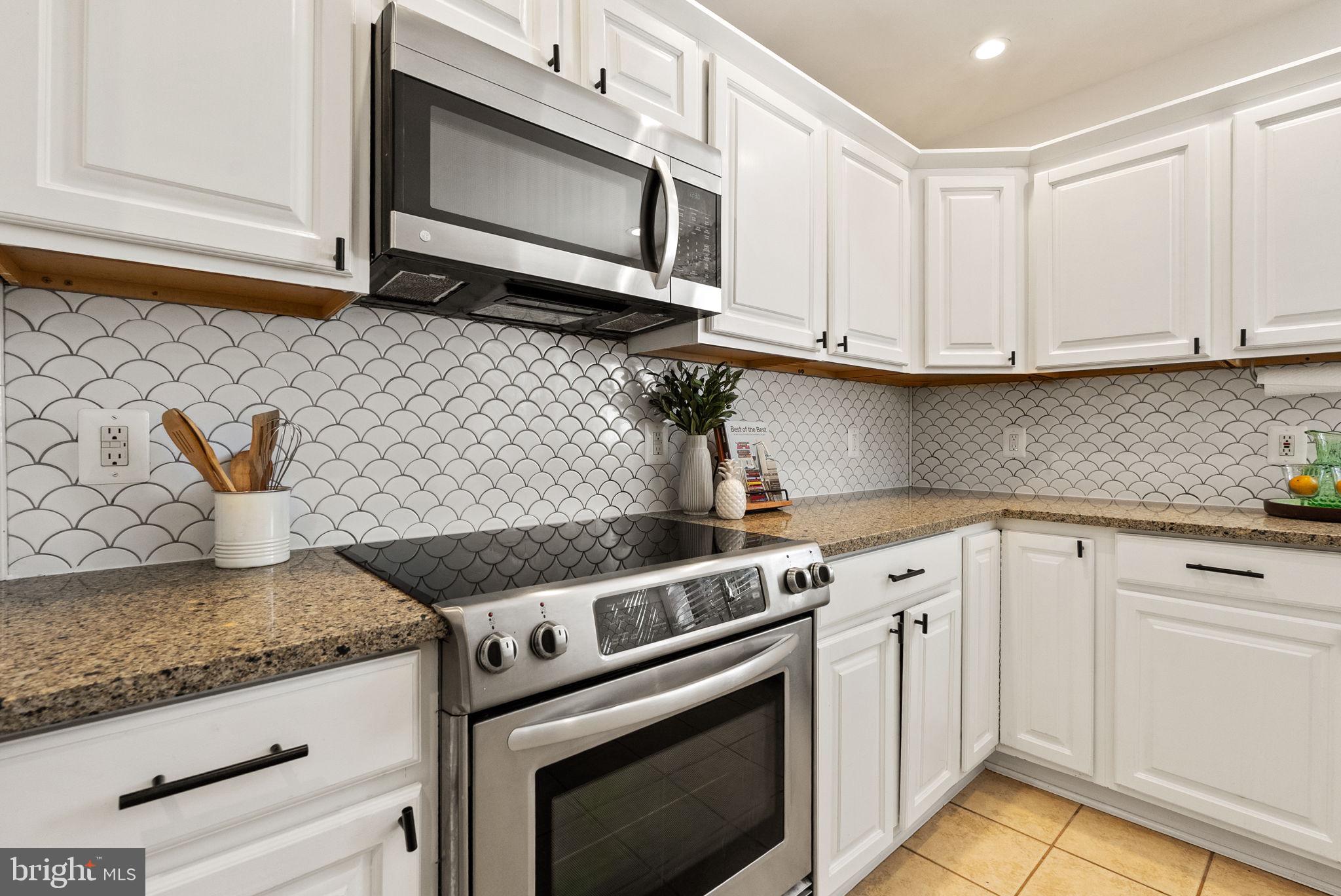 11026 Saffold Way Reston, VA 20190 - Photo 4 of 30 a kitchen with granite countertop cabinets stainless steel appliances and wooden floor