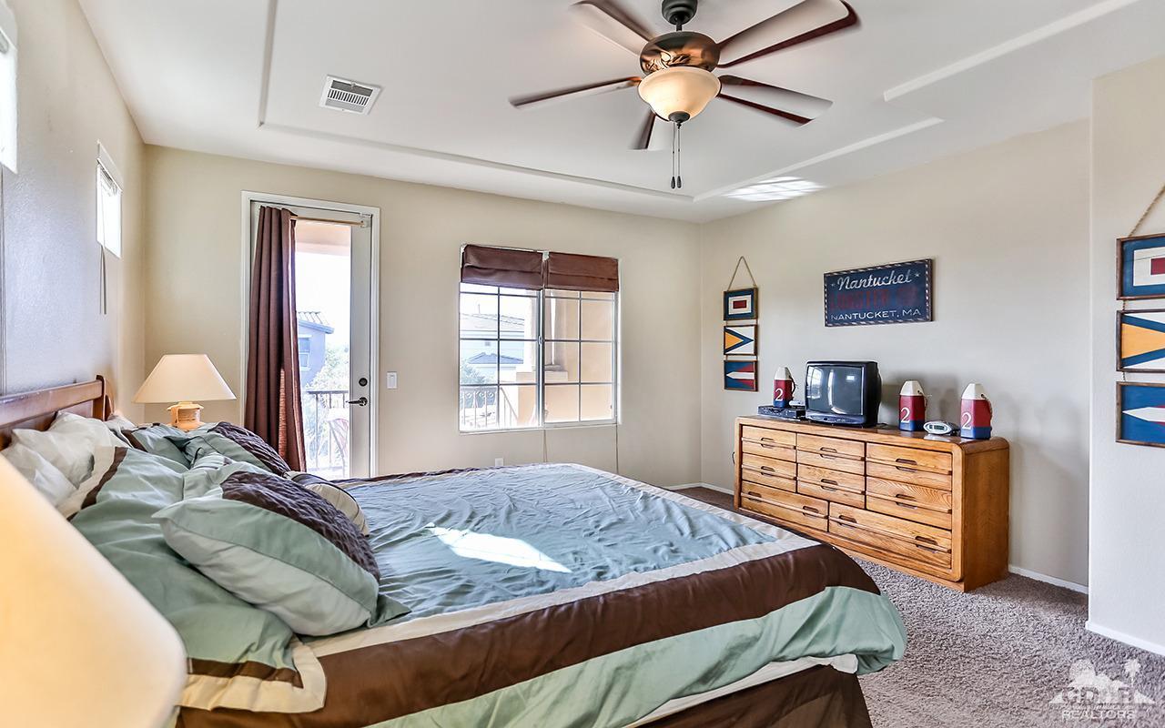 83330 Lightning Road Indio, CA 92203 - Photo 27 of 39 a bedroom with a bed and a chandelier