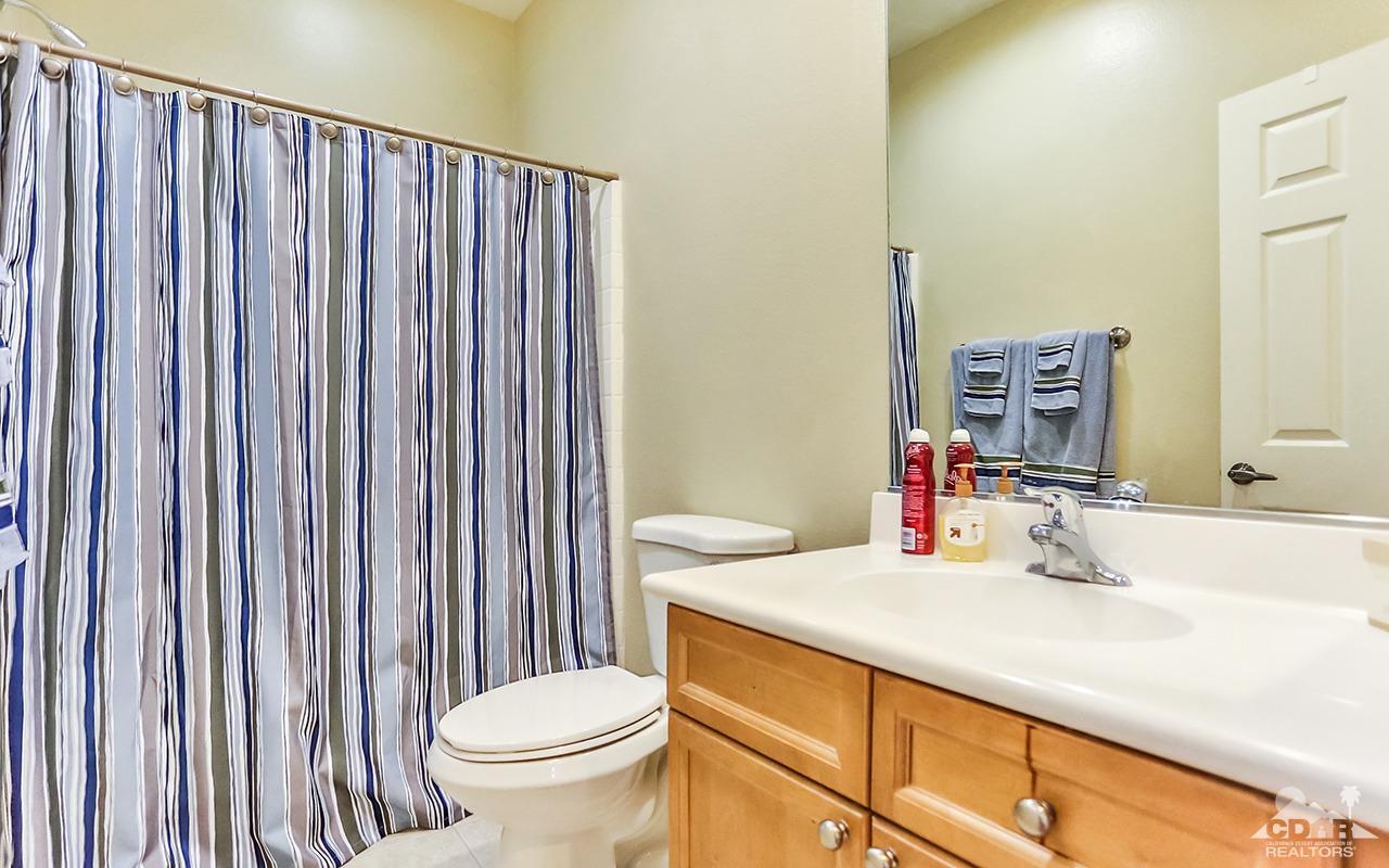 83330 Lightning Road Indio, CA 92203 - Photo 33 of 39 a bathroom with a sink a toilet and shower curtain