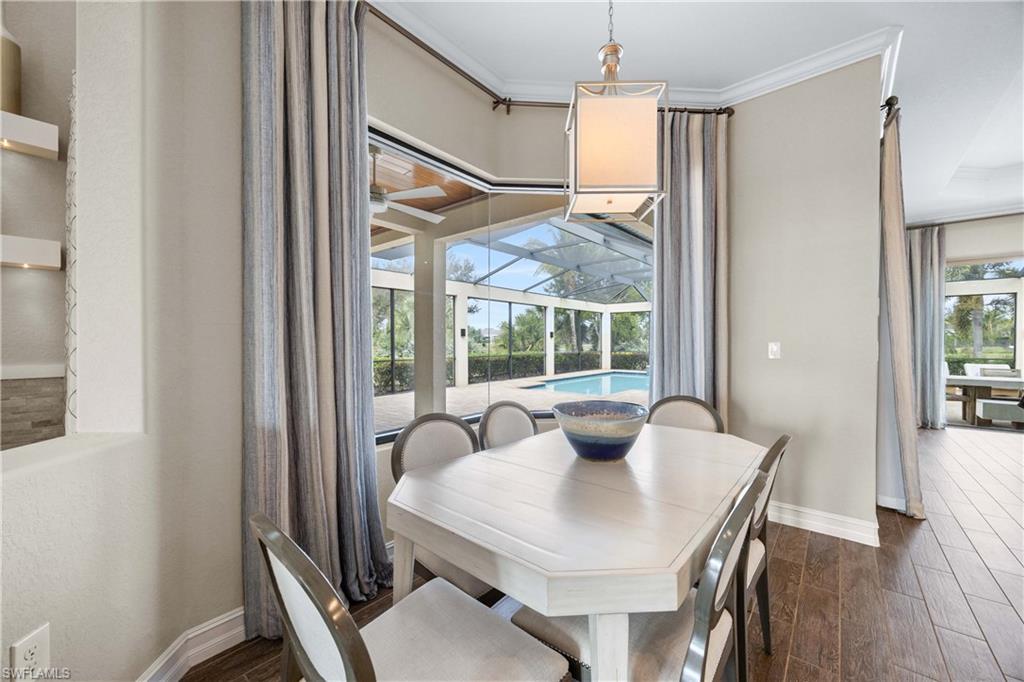 9852 Corso Bello Drive Naples, FL 34113 - Photo 2 of 50 Dining space with a sunroom, wood finish floors, and crown molding