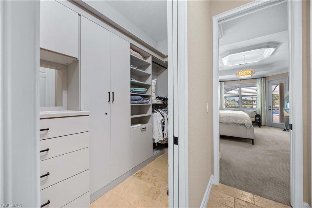 9852 Corso Bello Drive Naples, FL 34113 - Photo 27 of 50 Spacious closet with stone tile flooring and light colored carpet