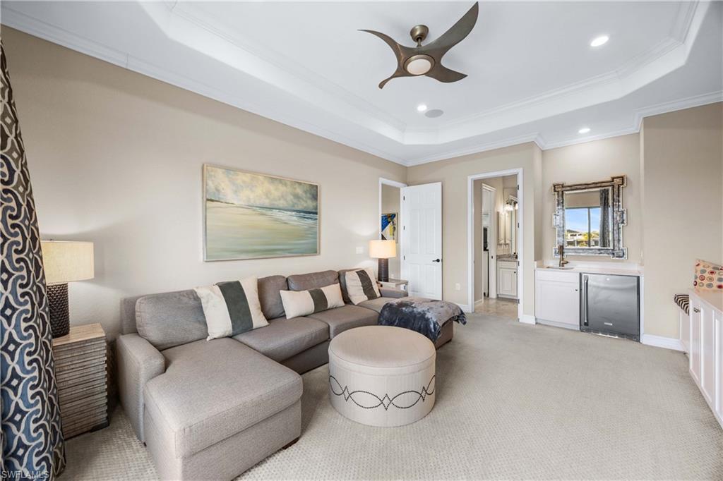 9852 Corso Bello Drive Naples, FL 34113 - Photo 32 of 50 Living room with crown molding, recessed lighting, a raised ceiling, ceiling fan, and light colored carpet