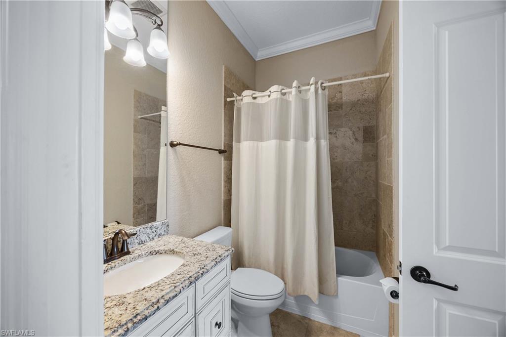 9852 Corso Bello Drive Naples, FL 34113 - Photo 33 of 50 Full bathroom with crown molding, shower / bath combo, vanity, and a textured wall