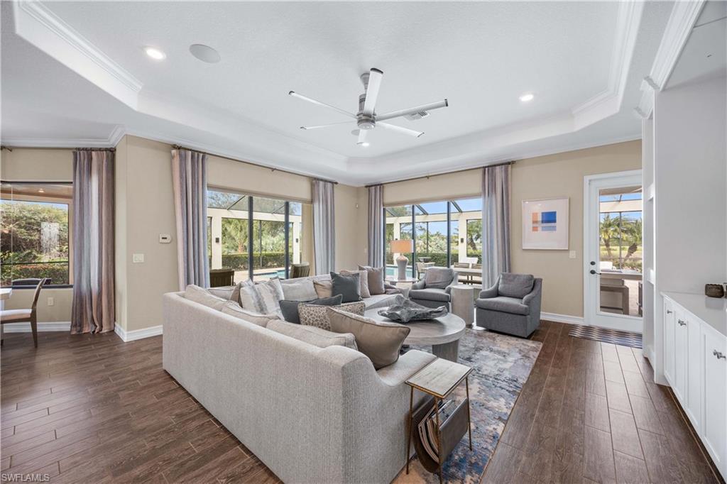 9852 Corso Bello Drive Naples, FL 34113 - Photo 7 of 50 Living area featuring dark wood finished floors, a ceiling fan, ornamental molding, a raised ceiling, and recessed lighting