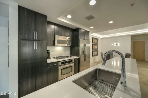 a kitchen with kitchen island granite countertop stainless steel appliances a sink cabinets and a counter top space