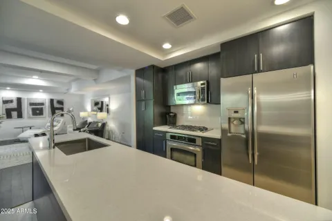 a kitchen with a refrigerator a sink and chairs