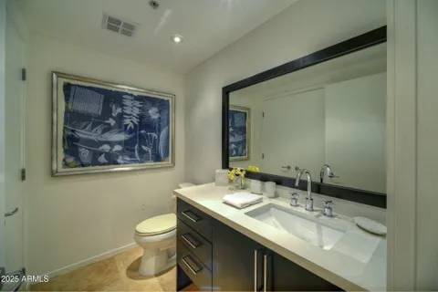 a bathroom with a granite countertop sink a toilet and a mirror