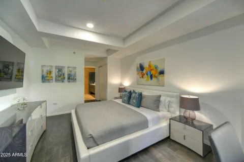 a bedroom with a bed and painting on the wall