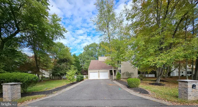 front view of a house with a yard and an trees
