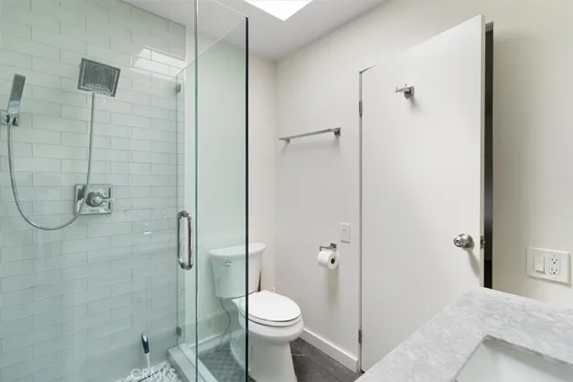 a bathroom with a shower a toilet and a window