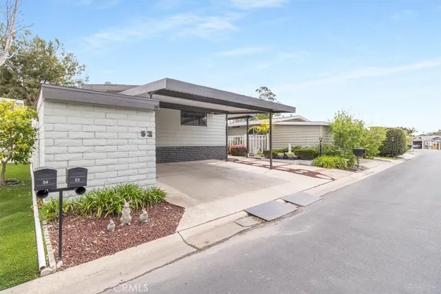 a backyard of a house with potted plants and large tree