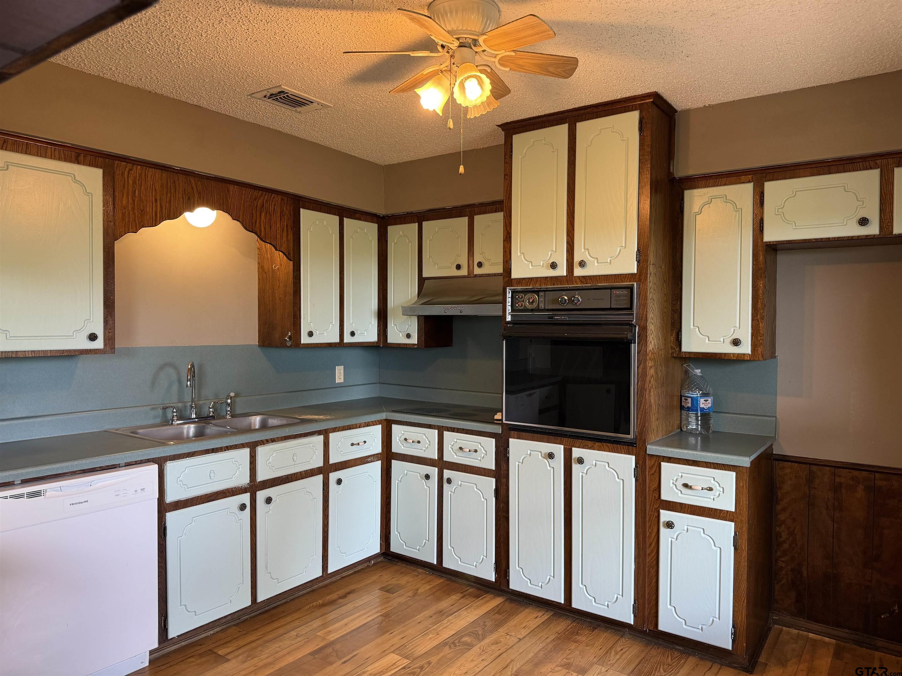300 Black Oak Road Como, TX 75431 - Photo 10 of 34 a kitchen with stainless steel appliances granite countertop a sink stove and wooden cabinets