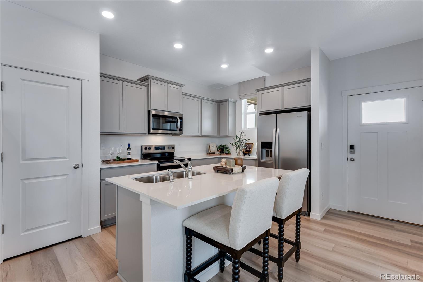 612 South Cabernet Avenue Fort Lupton, CO 80621 - Photo 14 of 49 a kitchen with stainless steel appliances a refrigerator stove microwave and cabinets