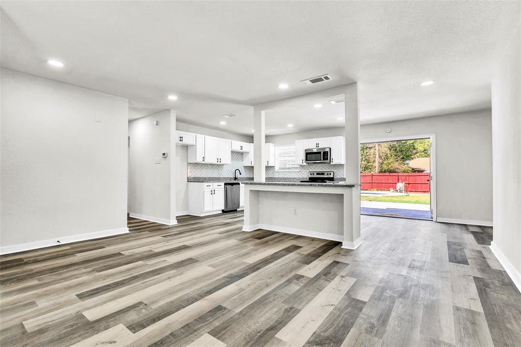 6321 Little Ranch Road North Richland Hills, TX 76182 - Photo 5 of 24 a kitchen with stainless steel appliances kitchen island granite countertop a refrigerator sink and white cabinets