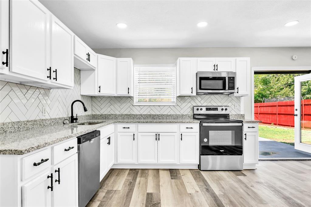 6321 Little Ranch Road North Richland Hills, TX 76182 - Photo 7 of 24 a kitchen with stainless steel appliances granite countertop a stove a sink and a microwave