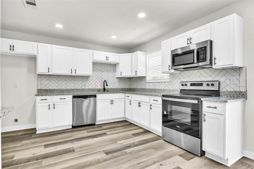 6321 Little Ranch Road North Richland Hills, TX 76182 - Photo 8 of 24 a kitchen with stainless steel appliances granite countertop a stove a microwave and a sink