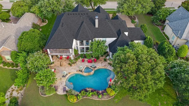 an aerial view of a house with a swimming pool a yard and a fountain