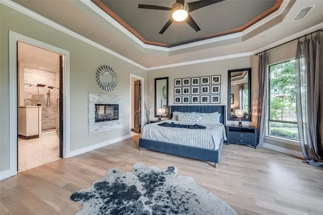 a spacious bedroom with a large bed and a chandelier